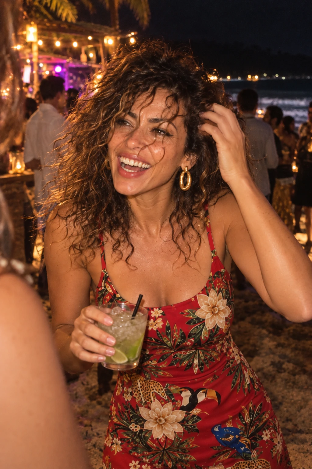 Modelo do vestido floral vermelho ri com um drink na festa